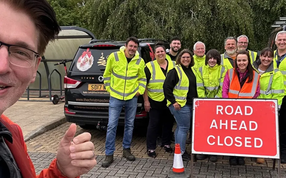 Rod Doyle with a Chapter 8 cohort behind a Road Ahead Closed sign