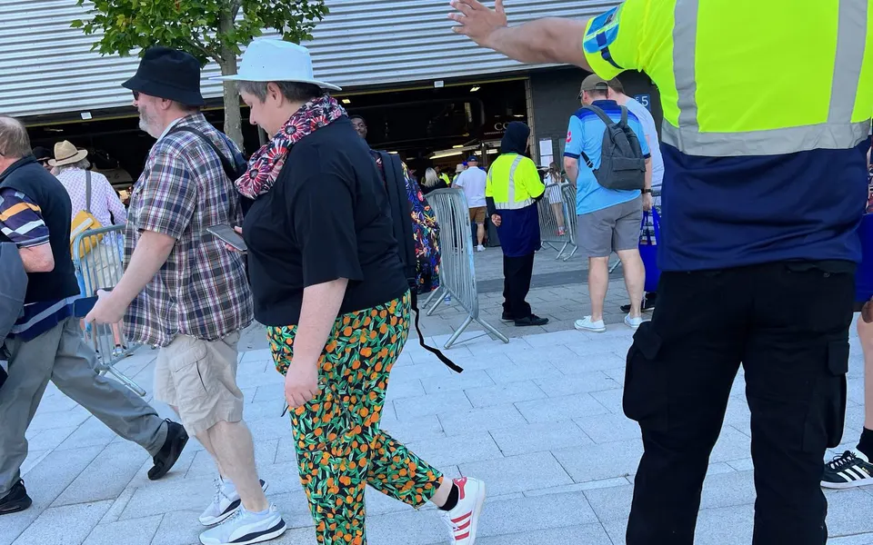 Steward directing spectators at a busy entrance